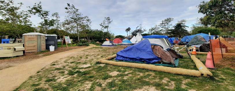 Tents with portable toilets and trash receptacles nearby